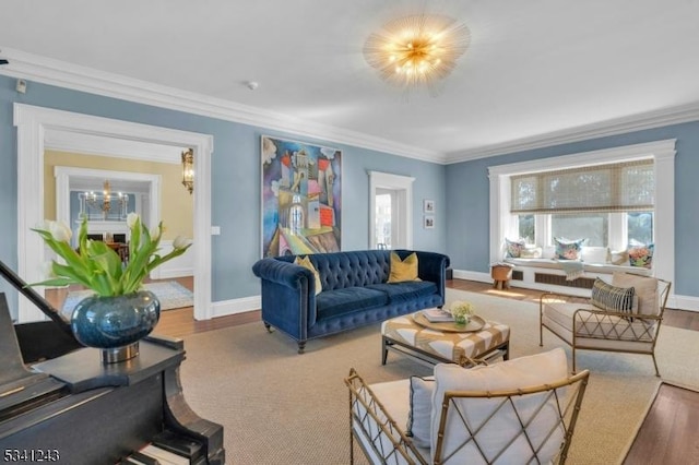 living area featuring baseboards, wood finished floors, and crown molding