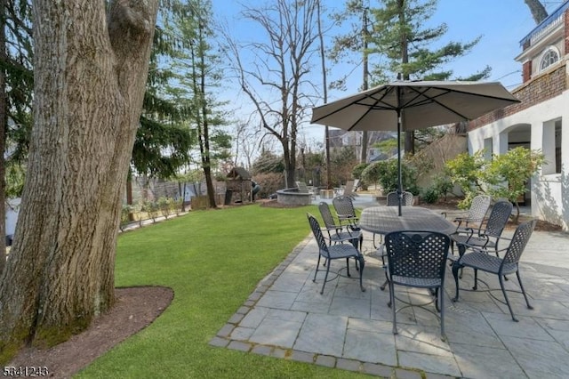 view of patio with outdoor dining area and fence