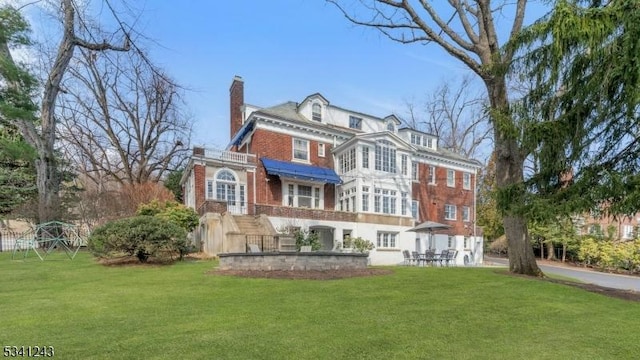 view of front of home with a chimney and a front yard