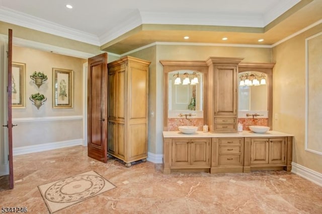 full bathroom featuring double vanity, crown molding, baseboards, and a sink