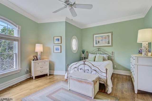 bedroom featuring ornamental molding, wood finished floors, and baseboards