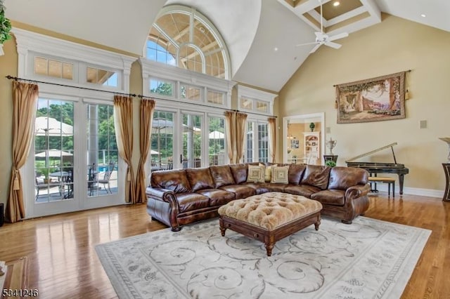 living room with ceiling fan, high vaulted ceiling, wood finished floors, and baseboards