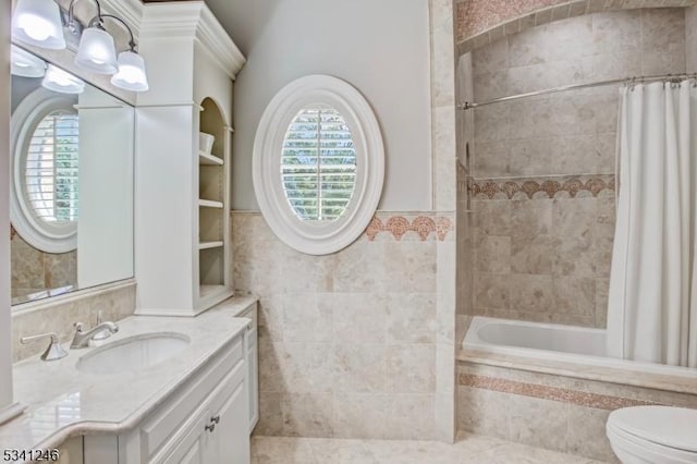 bathroom with tiled shower / bath, vanity, tile walls, and a healthy amount of sunlight