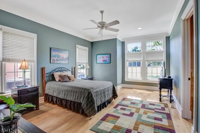 bedroom with baseboards, ceiling fan, light wood-style floors, and crown molding