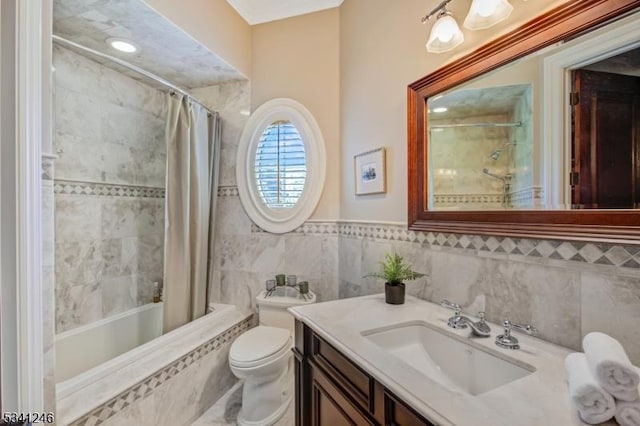 bathroom with tile walls, tiled shower / bath, toilet, and vanity