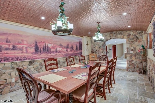 dining room featuring arched walkways, stone tile flooring, and recessed lighting