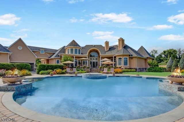 view of pool with a patio area and a pool with connected hot tub