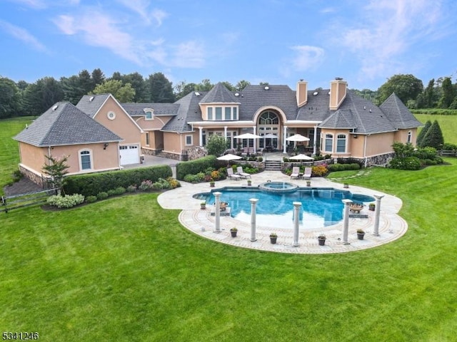 back of property with a lawn, a chimney, and a patio