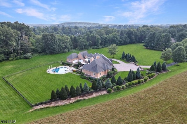 drone / aerial view featuring a rural view and a view of trees