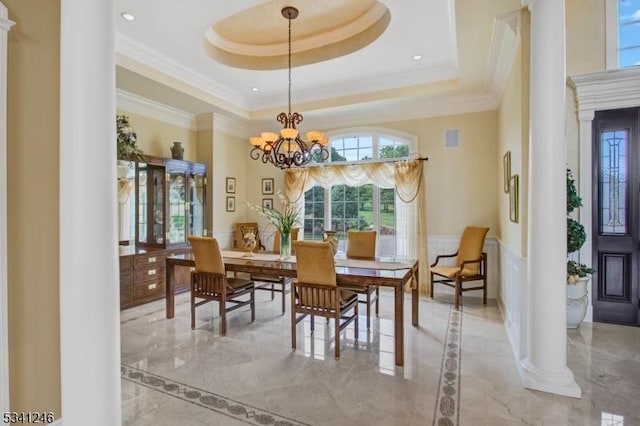 dining room with ornamental molding, marble finish floor, and a tray ceiling