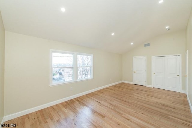 empty room with visible vents, light wood-style flooring, recessed lighting, baseboards, and vaulted ceiling