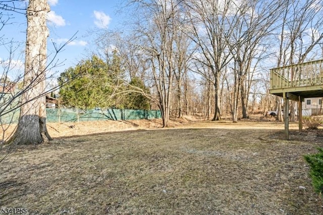 view of yard featuring a wooden deck and fence