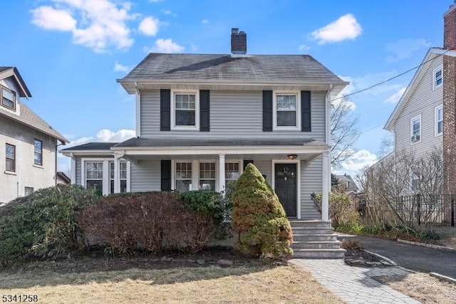 traditional style home featuring a porch and a chimney