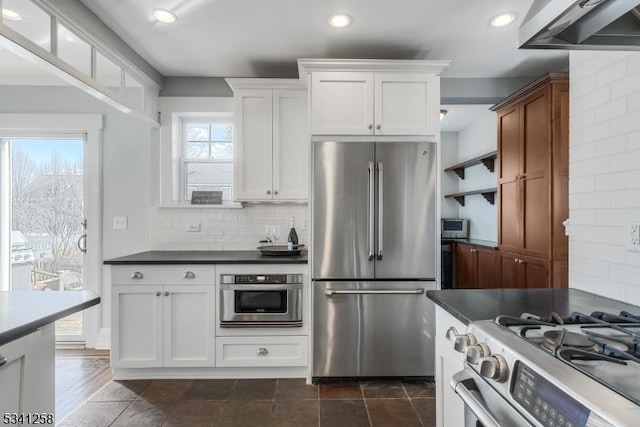 kitchen with dark countertops, appliances with stainless steel finishes, and backsplash