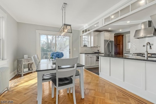 dining space with radiator heating unit, baseboards, and a wealth of natural light