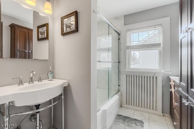 full bathroom featuring marble finish floor, combined bath / shower with glass door, and a sink