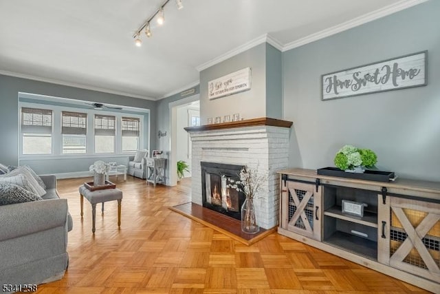 living area with ornamental molding, a brick fireplace, and track lighting