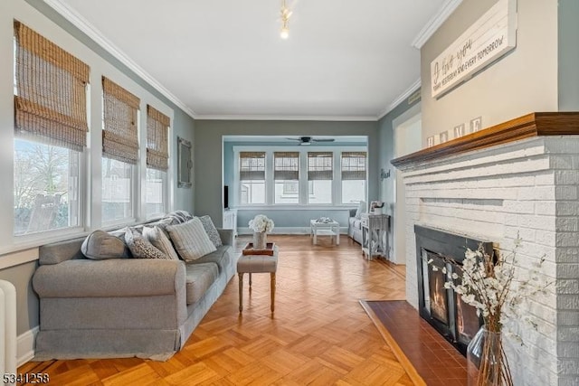 living room featuring ornamental molding, a fireplace, and a healthy amount of sunlight