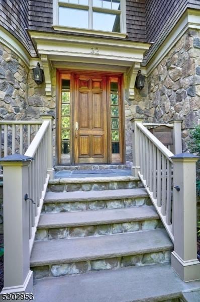 doorway to property featuring stone siding and covered porch