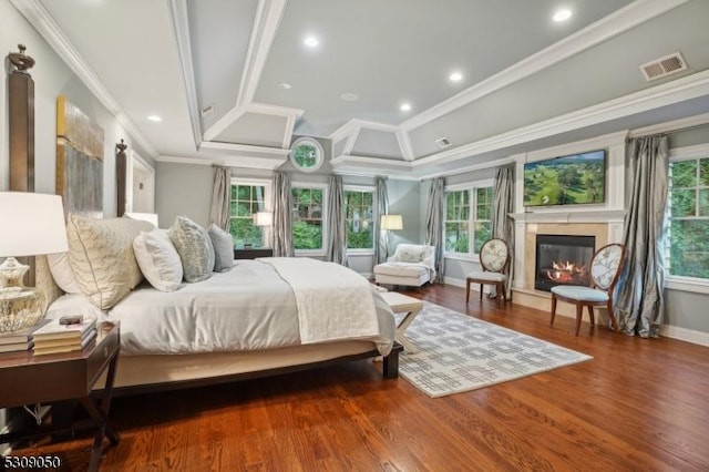 bedroom featuring visible vents, ornamental molding, wood finished floors, and a high end fireplace