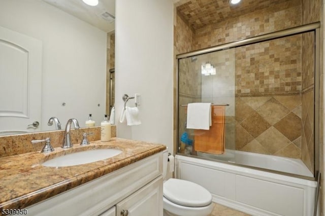 bathroom with visible vents, bath / shower combo with glass door, vanity, and toilet