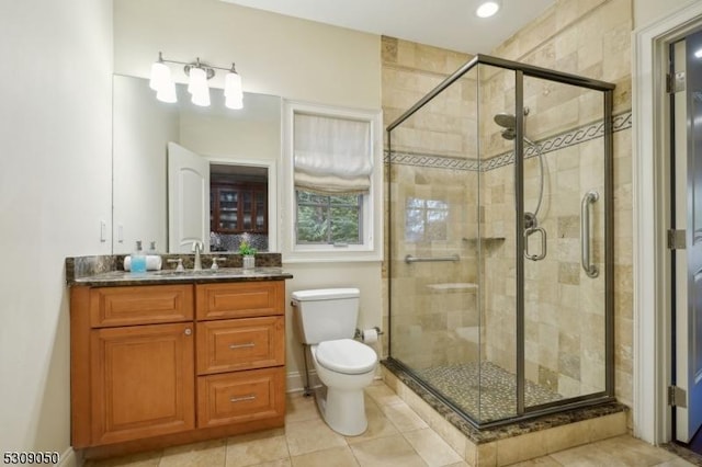 bathroom featuring toilet, a stall shower, and vanity