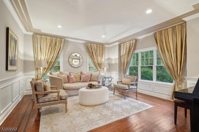 sitting room featuring dark wood-style flooring, crown molding, and a decorative wall