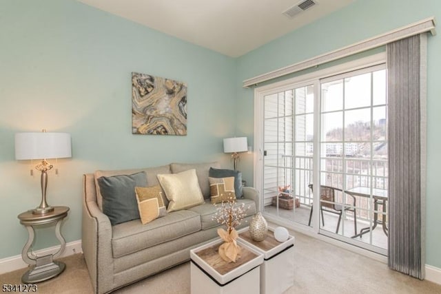 living area with carpet, visible vents, and baseboards