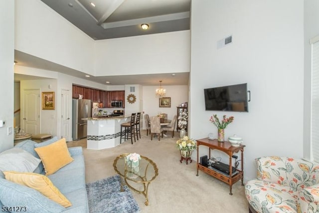 living area featuring a chandelier, visible vents, light carpet, and a towering ceiling