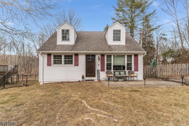 cape cod house featuring a patio, a front lawn, a shingled roof, and fence