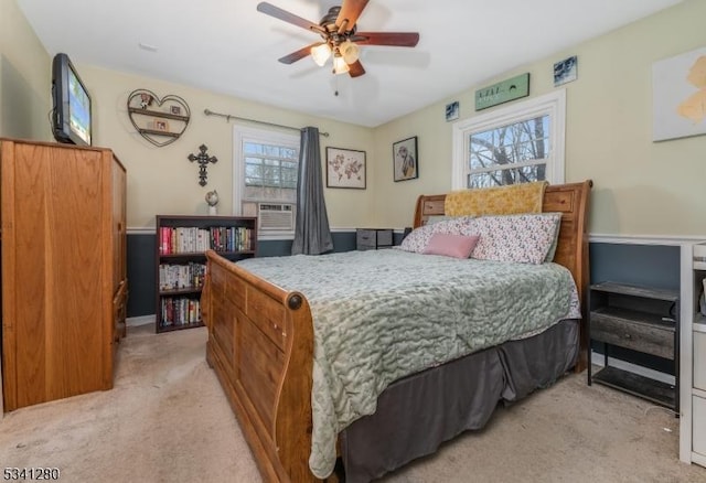 bedroom with ceiling fan, cooling unit, and light colored carpet