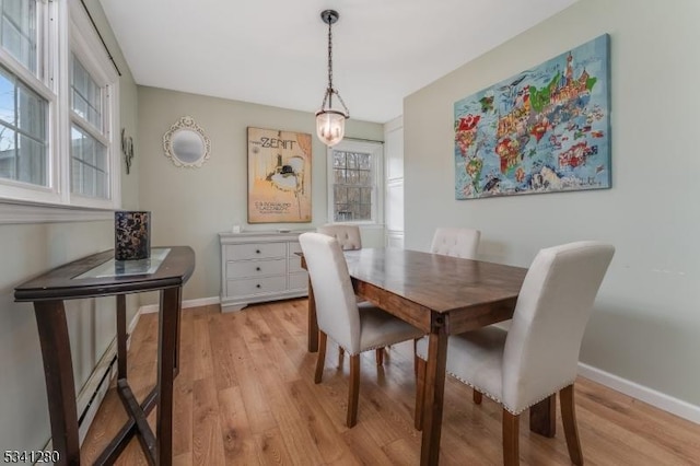 dining area featuring light wood finished floors and baseboards