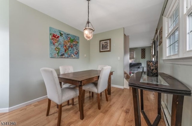 dining area featuring light wood finished floors and baseboards