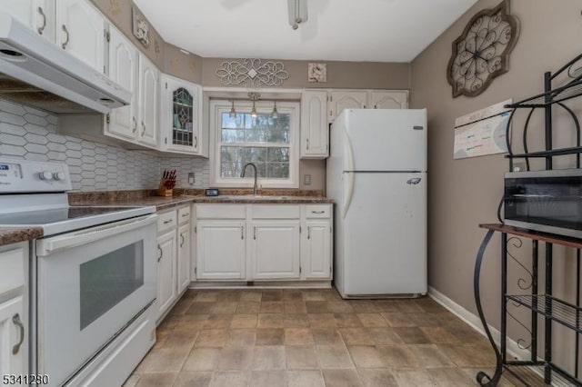 kitchen featuring under cabinet range hood, white appliances, a sink, white cabinets, and decorative backsplash