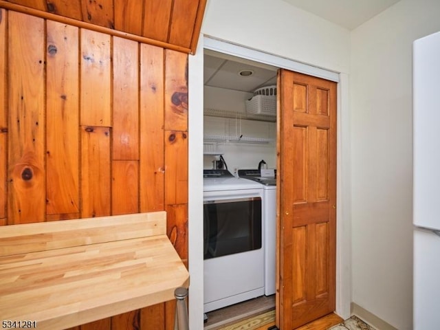 laundry room with light wood-type flooring, laundry area, and washer and clothes dryer