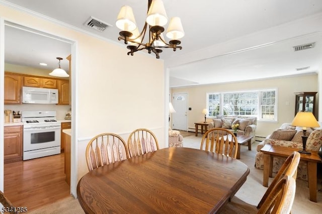 dining space featuring visible vents, a notable chandelier, and crown molding