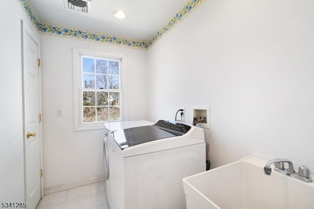 laundry area with visible vents, washer and clothes dryer, a sink, light tile patterned floors, and laundry area