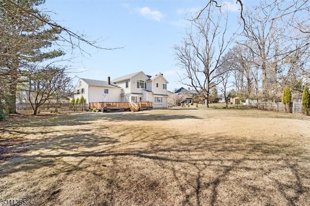 exterior space featuring a lawn, a deck, and fence