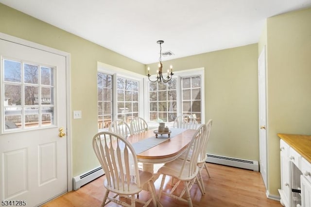 dining room featuring a wealth of natural light, light wood-type flooring, and baseboard heating