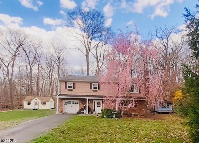 view of front facade with a garage, a front yard, and driveway