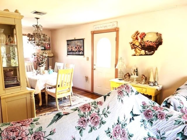 dining area with light wood-style floors, visible vents, and a notable chandelier