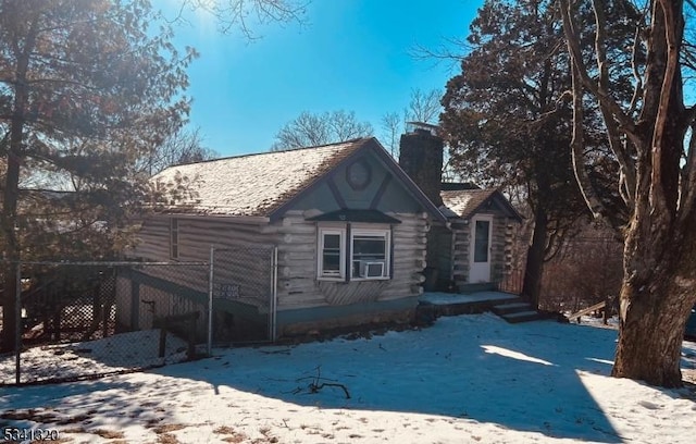 view of front of home with a chimney, fence, and log exterior