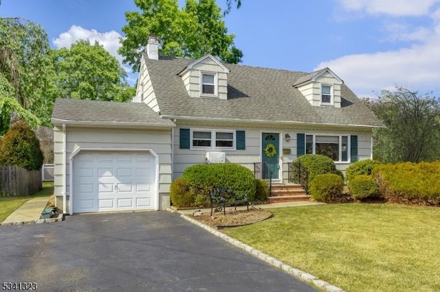 new england style home with aphalt driveway, a shingled roof, an attached garage, fence, and a front lawn