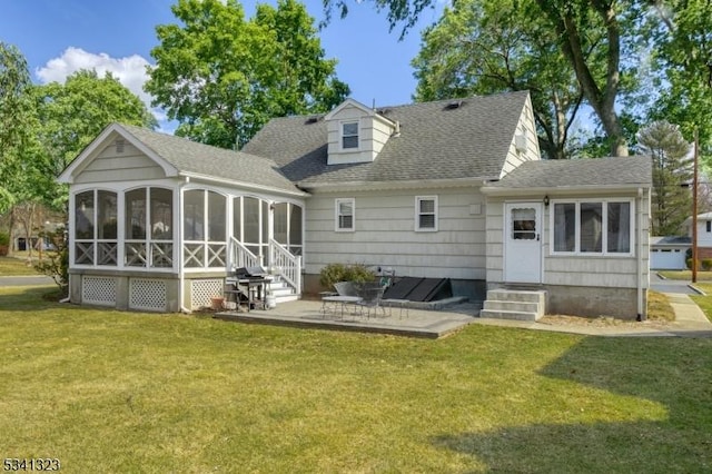 rear view of property with a shingled roof, entry steps, a sunroom, and a yard