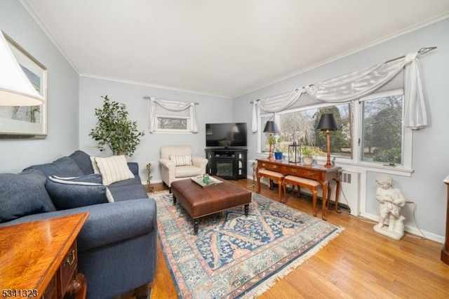 living room featuring ornamental molding, wood finished floors, a wealth of natural light, and baseboards