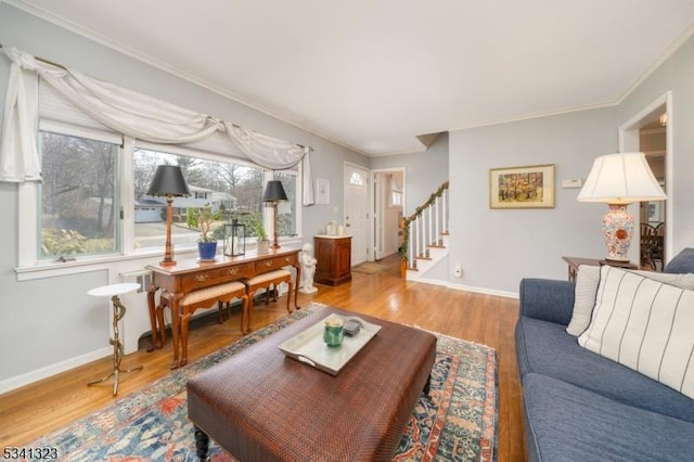 living area with stairs, baseboards, wood finished floors, and crown molding