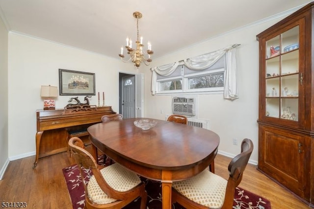 dining space featuring a chandelier, light wood-type flooring, crown molding, and baseboards