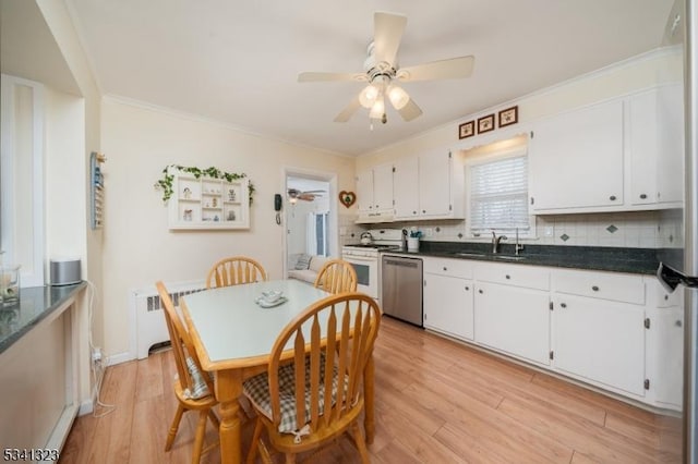 kitchen with light wood finished floors, dishwasher, radiator heating unit, white gas stove, and backsplash