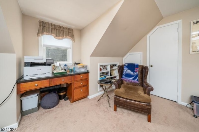 office area with light colored carpet, vaulted ceiling, and baseboards