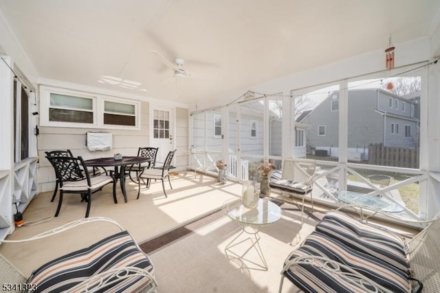 sunroom / solarium with a healthy amount of sunlight and a ceiling fan